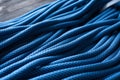 Lying on the wooden table. Isolated photo of climbing knots. Top view of blue colored cables