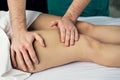 Lymphatic drainage massage of the hips. Man`s hands