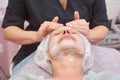 Lymphatic face massage, mature woman.