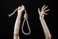 Lynching and suicide theme: man's hand holding a loop of rope for hanging on black isolated background Royalty Free Stock Photo