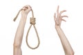 Lynching and suicide theme: man's hand holding a loop of rope for hanging on white isolated background Royalty Free Stock Photo