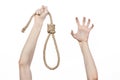 Lynching and suicide theme: man's hand holding a loop of rope for hanging on white isolated background