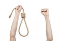 Lynching and suicide theme: man's hand holding a loop of rope for hanging on white isolated background