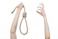 Lynching and suicide theme: man's hand holding a loop of rope for hanging on white isolated background