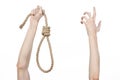 Lynching and suicide theme: man's hand holding a loop of rope for hanging on white isolated background