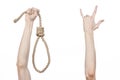 Lynching and suicide theme: man's hand holding a loop of rope for hanging on white isolated background