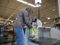 Lynnwood, WA USA - circa March 2022: View of a woman in a gray jacket checking out in the self-checkout area of a Town and Country