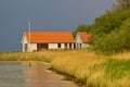 Lyo, Denmark - May 28th, 2011 - White clapboard house with red tile roof housing the marina facilities on the reed-covered shore o