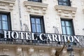 Carlton hotel text brand and logo sign on wall facade historical hotel luxury balcony signboard