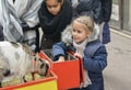 LYON, FRANCE - DECEMBER 11, 2016: Girl feeds young white goat at a fair Royalty Free Stock Photo