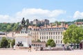 Roi Louis XIV statue on the Place Bellecour Square, in downtown Lyon, with pedestrians passing by.