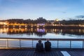 Senior people, and old couple of lovers, sitting on the quays of the riverbank of the rhone admiring the river during evening Royalty Free Stock Photo