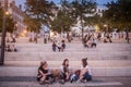 French people, mainly women and girls sitting on the riverbank of the Rhone quais in the evening while people are gathering