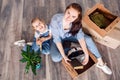 Mother and daughter sort things out after moving to a new house or apartment. A woman and a little girl sit on the floor Royalty Free Stock Photo