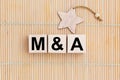 M and A - Merger and Acquisition - word wooden cubes