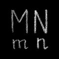 M, n handwritten white chalk letters isolated on black background