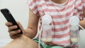 Mom pump breastmilk and play phone