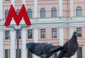 M-symbol of the underground metro and pigeons