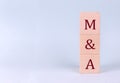 M and A on wooden cubes on a blue background