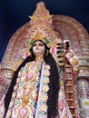 Maa saraswati , a hindu goddess at puja pandal with two swans and a veena with a blue background