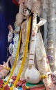 Maa saraswati , a hindu goddess at puja pandal with a veena with a blue background