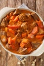 Maafe a spicy peanut stew made with beef, sweet potatoes and carrots closeup in the pan. Vertical top view