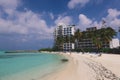 People near the White Sandy Beach with the Palm Trees and Hotel Building on the Maldivian Paradise Island