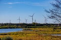 Maas river and floodplain with windmills and electric pylons in Belgian countryside