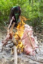 Maasai warriors cooking goat meat at a campfire