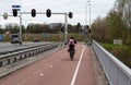 Maastricht, Limburg - The Neteherlands - Mother driving a bike over a double laned path over the highway bridge Royalty Free Stock Photo