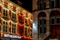 Maastricht, NETHERLANDS - December 25, 2019 Urban Christmas facade decorations. Christmas garland lights up on window house.