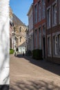 A look through in a typical historical street with cobble stones in Maastricht with a view on the basilica of our lady and a forme