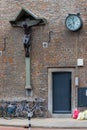 Religious cross with Jesus Christ and a clock on the side of a building in Maastricht Royalty Free Stock Photo