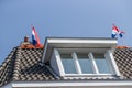 Maastricht, South Limburg, Netherlands. April 27, 2022. King`s day, man on the gabled roof with two Dutch flags