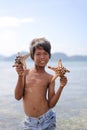 MABUL ISLAND, SABAH, MALAYSIA - MARCH 3: Local sea gypsy kid hold a starfish March 3, 2013 in Mabul Island, Sabah, Malaysia.