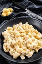 Mac and cheese. American style macaroni pasta in cheesy sauce. Black wooden background. Top view Royalty Free Stock Photo