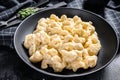 Mac and cheese. American style macaroni pasta in cheesy sauce. Black wooden background. Top view Royalty Free Stock Photo