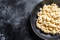 Mac and cheese. American style macaroni pasta in cheesy sauce. Black wooden background. Top view. Copy space Royalty Free Stock Photo