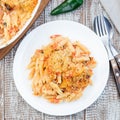 Mac and cheese with mini penne pasta, on white plate, closeup, top view, square format Royalty Free Stock Photo