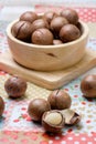 Macadamia on napery and wooden bowl