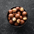 Macadamia nut in bowl on black stone background. Royalty Free Stock Photo