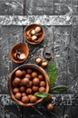 Macadamia nut in bowl on black stone background. Royalty Free Stock Photo