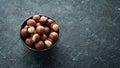 Macadamia nut in bowl on black stone background. Royalty Free Stock Photo