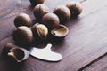 Macadamia nuts on a brown wooden table. Special metal key for opening macadamia nuts