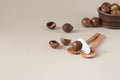 Macadamia nuts in ceramic bowl on beige background. Nuts with sawn nutshells and with opener key on the wooden spoon. Healthy