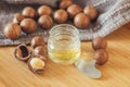 Macadamia nuts and macadamia oil on a wooden background, cosmetic oils