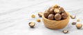 Macadamia nuts in wood bowl with broken macadamia on marble table background Royalty Free Stock Photo