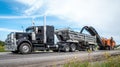 Macamic, Quebec, Canada, 2023-08-21 : Black semi trailer with a orange planer working on a road construction site