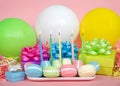 Macaron birthday party with candles balloons and colorful presents Royalty Free Stock Photo