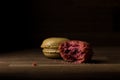 Macaron with bite mark, Pink and Green Macarons on wooden table, breakfast in morning light